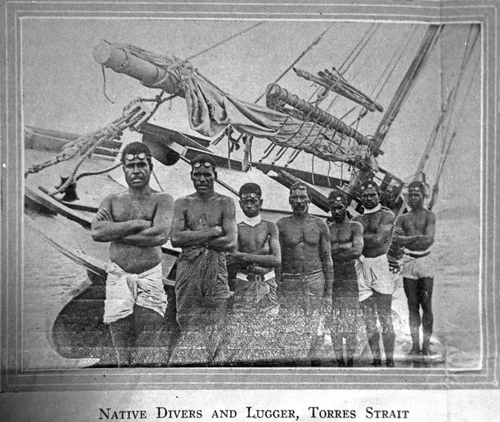 Image of a group of people standing in front of a boat
